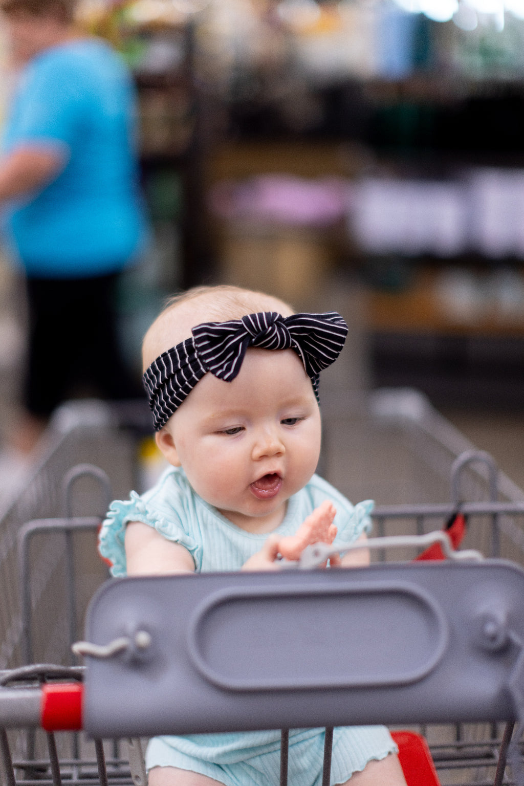 Baby with Busy Baby mat on shopping cart